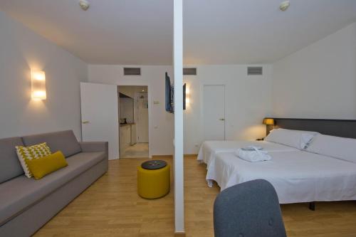 a hotel room with a bed and a couch at Aparthotel Atenea Valles in Granollers