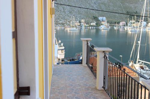 a balcony with a view of a marina with boats at Gompos Apartment - Cozy Apartment next to the sea - Amazing Sea View in Symi
