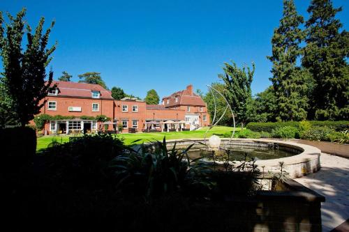 a large house with a pond in front of it at The Pinewood Hotel in Slough