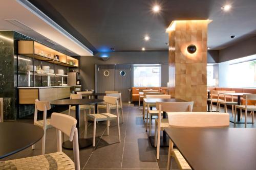 a dining room with tables and chairs in a restaurant at Aparthotel Atenea Valles in Granollers