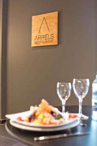 a plate of food on a table with two wine glasses at Aparthotel Atenea Valles in Granollers