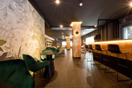 a restaurant with green chairs and a bar at Aparthotel Atenea Valles in Granollers