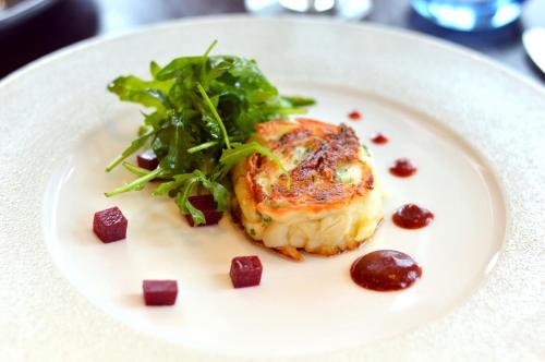 a white plate with a piece of food with a salad at The Pinewood Hotel in Slough