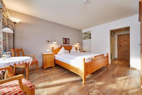 a bedroom with a large bed and a table at Landhaus Sonnenbichl Mittenwald in Mittenwald