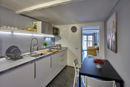 a kitchen with white cabinets and a black table at San Giorgio 2 in Bologna