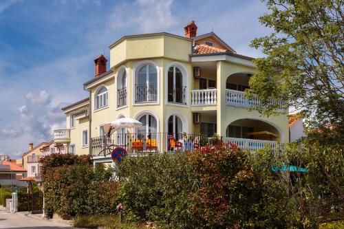 a large white house with a balcony on a street at Apartments Dora in Medulin