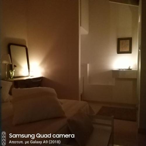 a room with a bed and a mirror and a lamp at Ble Mavi - Studio for 2 in Vouni