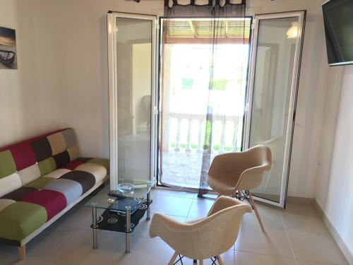 a living room with a couch and chairs and a window at Villa Panorea in Moraitika