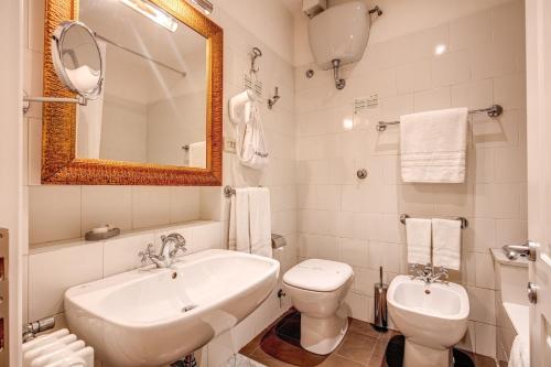 a bathroom with a sink, toilet and bathtub at Hotel Cortina in Rome