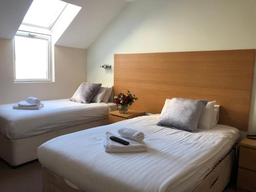 a hotel room with two beds and a window at The Anchor Ely in Ely