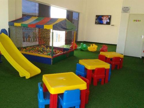 a room with a play area with tables and a slide at Lacqua diromaa com fogão, geladeira, micro-ondas, Park aquático 24h, acomoda até 5 pessoas in Caldas Novas