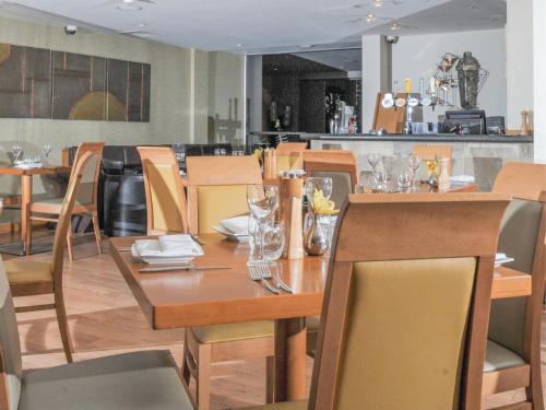 a dining room table and chairs in a kitchen at The Pinewood Hotel in Slough