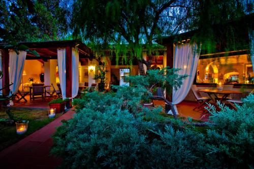 a garden with white umbrellas and tables and plants at Nora Club Hotel & Spa in Pula