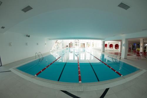 a swimming pool in a large building at WISH Aqua&SPA Resort in Vishenki