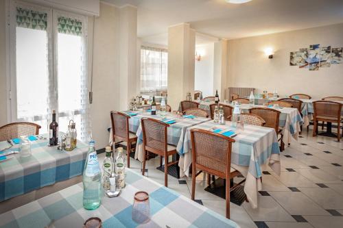 サルソマッジョーレ・テルメにあるAlbergo Ederaのテーブルと椅子(青と白のテーブルクロス付)が備わるレストラン
