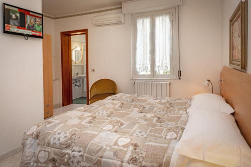 a bedroom with a large bed and a window at Albergo Edera in Salsomaggiore Terme