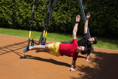 a man is hanging on a swing set at WISH Aqua&SPA Resort in Vishenki