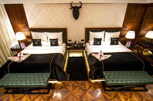 two beds in a hotel room with two chairs at DATA Resort by Della Adventure in Lonavala