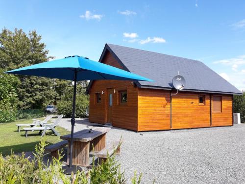 a large blue umbrella in front of a cabin at Domaine du Hulobiet in Fromelennes