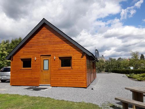 a small wooden cabin with a door in a parking lot at Domaine du Hulobiet in Fromelennes