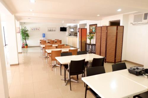 a dining room with tables and chairs in a building at My North Star Hotel in Tarlac