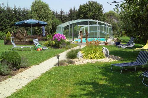 a garden with a pool and people in a greenhouse at Hotel Garni Thermenoase in Bad Blumau