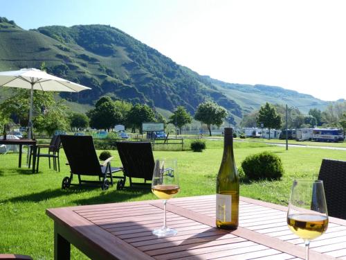 una botella de vino sentada en una mesa con dos copas en Mosel Palais, en Ürzig