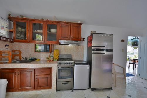 a kitchen with stainless steel appliances and wooden cabinets at Villa Alégria in Santa Bárbara de Samaná