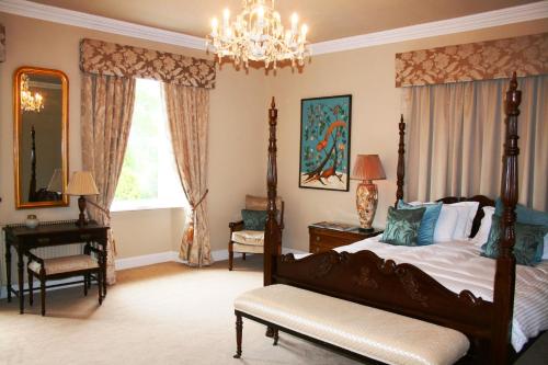 a bedroom with a bed and a chandelier at The Old Parsonage Country House in Berwick-Upon-Tweed