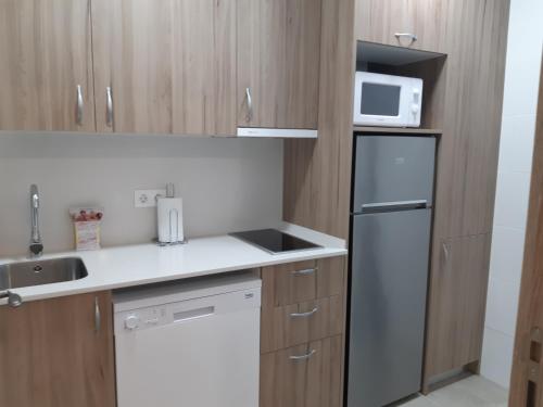 a small kitchen with a refrigerator and a microwave at Cal Ribero in Villanova de la Sal