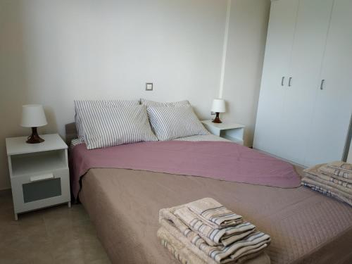 a bedroom with a bed with a pile of towels on it at Athani Summer House (Apartments 03 - 04) in Athanion
