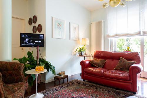 a living room with a red couch and a tv at L'Angolo di Lore B&B in Fano