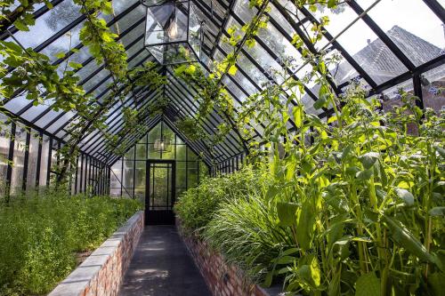 a green greenhouse with plants in it at Hotel de Leijhof Oisterwijk in Oisterwijk