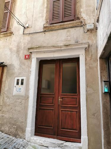 a building with a wooden door on the side of it at Apartment Niko in Piran