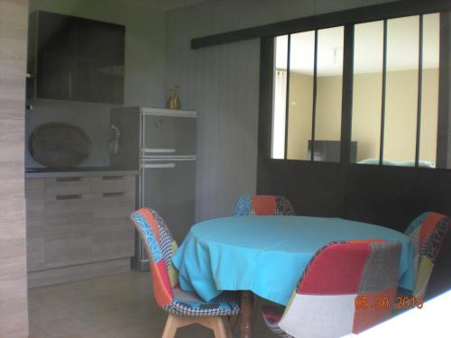 - une cuisine avec une table, des chaises et un comptoir dans l'établissement Gite de Grandcamp Maisy, à Grandcamp-Maisy