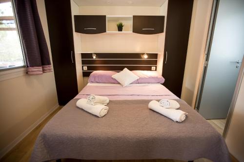 a bedroom with two beds with white towels on them at Mobile homes Ante Mali in Kolan
