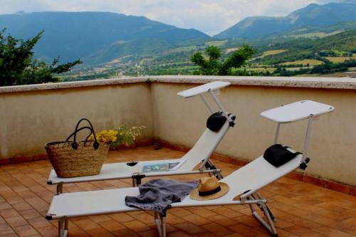 two chairs on a balcony with a view of mountains at Rustic Country House in Smirra