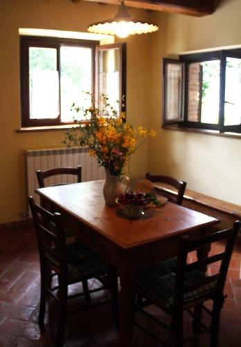 a dining room table with a vase of flowers on it at Rustic Country House in Smirra