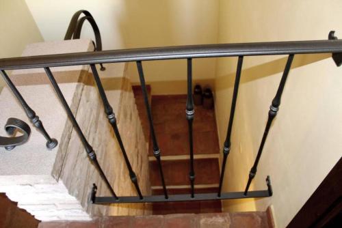 a staircase with a metal railing in a building at Rustic Country House in Smirra
