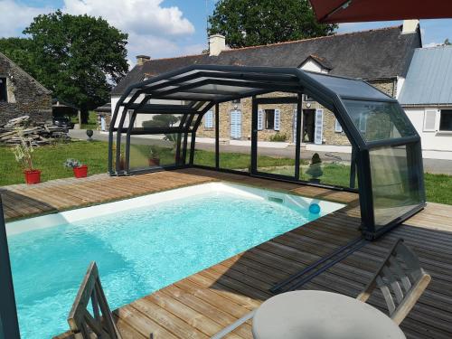 un pabellón sobre una piscina en una terraza en LA GALNAIS, en Ploërmel