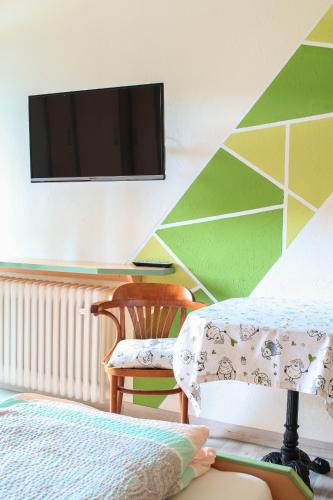 a bedroom with two beds and a tv on a wall at Gasthof Kornbachtal in Gefrees