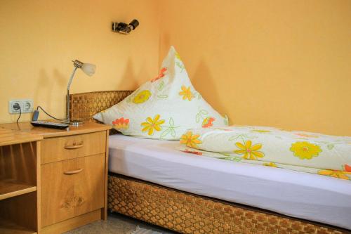 a bedroom with a bed with a pillow on it at Gasthof Kornbachtal in Gefrees