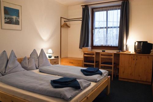 1 dormitorio con 2 camas, escritorio y ventana en Adler Panzio, en Budaörs
