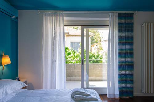 sypialnia z łóżkiem i dużym oknem w obiekcie L'Angolo di Lore B&B w mieście Fano