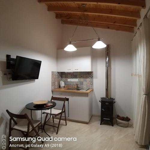 a kitchen with a small table and a kitchen with a tv at Ble Mavi - Studio for 2 in Vouni