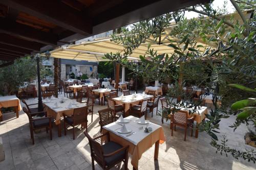 an outdoor restaurant with tables and chairs and an umbrella at Villa Riva in Makarska
