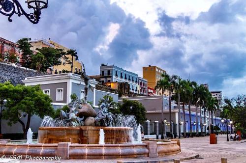 a fountain in the middle of a city with buildings at Navona Studios in San Juan