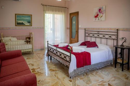 um quarto com uma cama grande e um sofá vermelho em Casa vacanze Gioia em Trecastagni