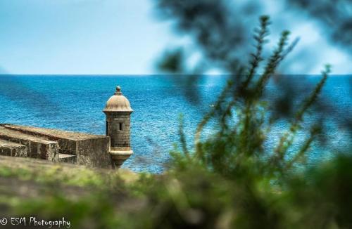 a lighthouse sitting on top of a building next to the water at Navona Studios in San Juan