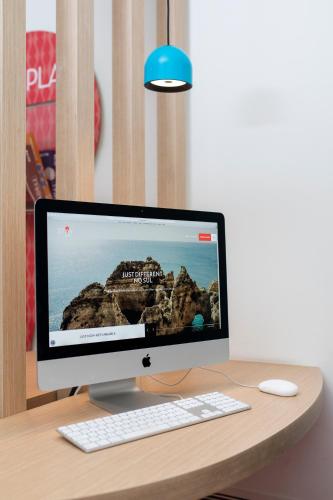 a computer monitor and a keyboard and mouse on a desk at Stay Hotel Coimbra Centro in Coimbra